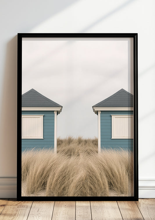 Fotoposter mit symmetrischen Strandhütten im schwarzen Rahmen vor heller Wand