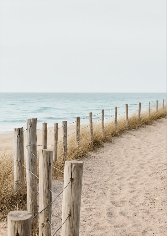 Holzpfosten mit Draht entlang eines Sandwegs am Meer, von Strandgras gesäumt