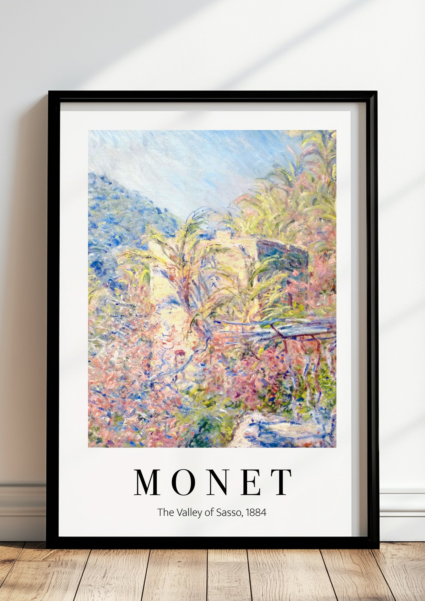 The Valley of the Sasso von Claude Monet als Poster, in schwarzem Rahmen, stehend auf dem Boden, angelehnt an einer Wand