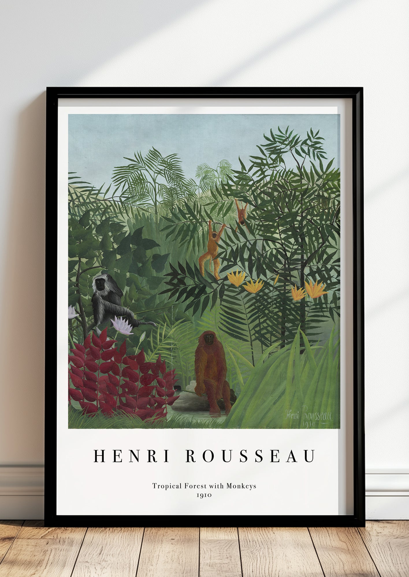 Tropical Forest with Monkeys von Henri Rousseau als Poster, in schwarzem Rahmen, stehend auf dem Boden, angelehnt an einer Wand
