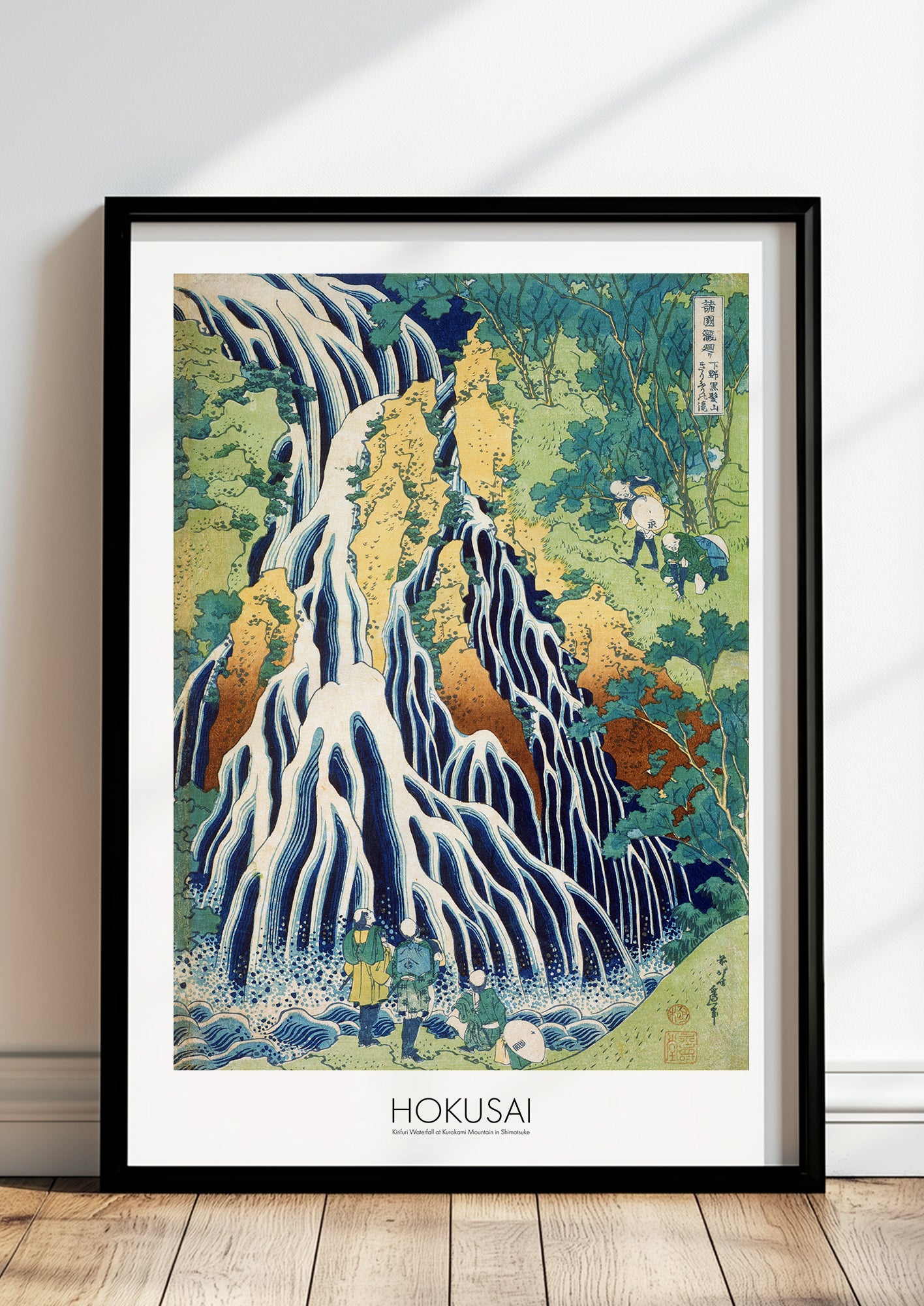 Kirifuri Waterfall at Kurokami Mountain in Shimotsuke von Hokusai als Poster, in schwarzem Rahmen, stehend auf dem Boden, angelehnt an einer Wand