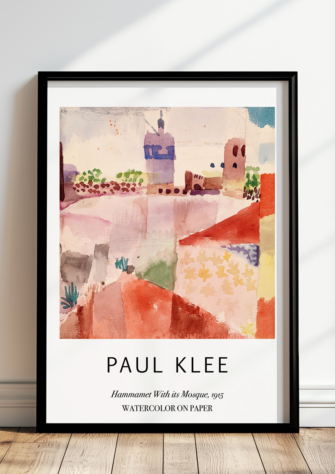 Hammamet With its Mosque von Paul Klee als Poster, in schwarzem Rahmen, stehend auf dem Boden, angelehnt an einer Wand