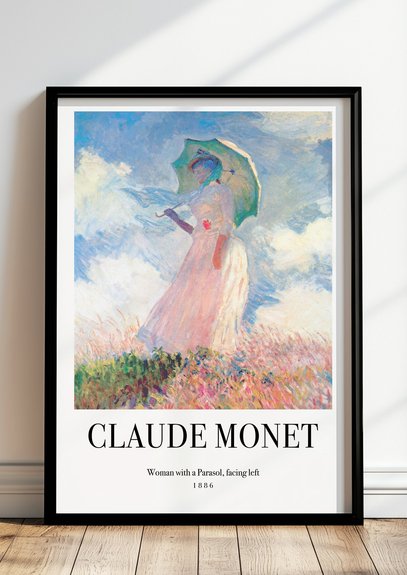 Woman with a Parasol, facing left von Claude Monet als Poster, in schwarzem Rahmen, stehend auf dem Boden, angelehnt an einer Wand