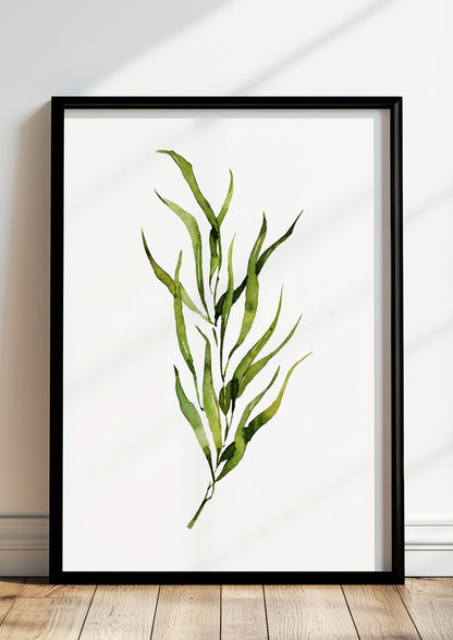 Gerahmtes Poster mit grünem Aquarellzweig lehnt auf dem Boden vor einer hellen Wand