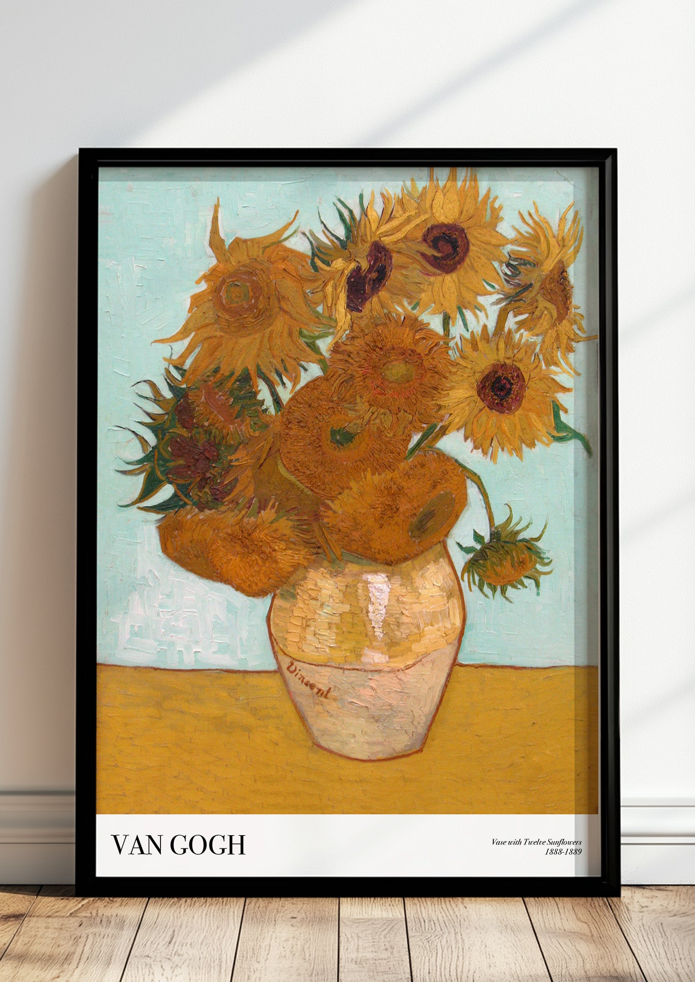 Vase with Twelve Sunflowers von Vincent van Gogh als Poster, in schwarzem Rahmen, stehend auf dem Boden, angelehnt an einer Wand