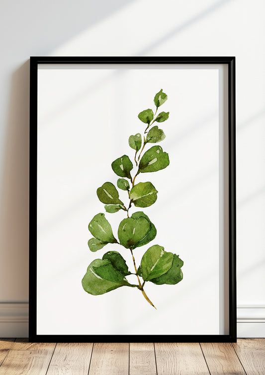 Gerahmtes Poster mit Aquarell-Eukalyptuszweig lehnt auf dem Boden vor einer hellen Wand