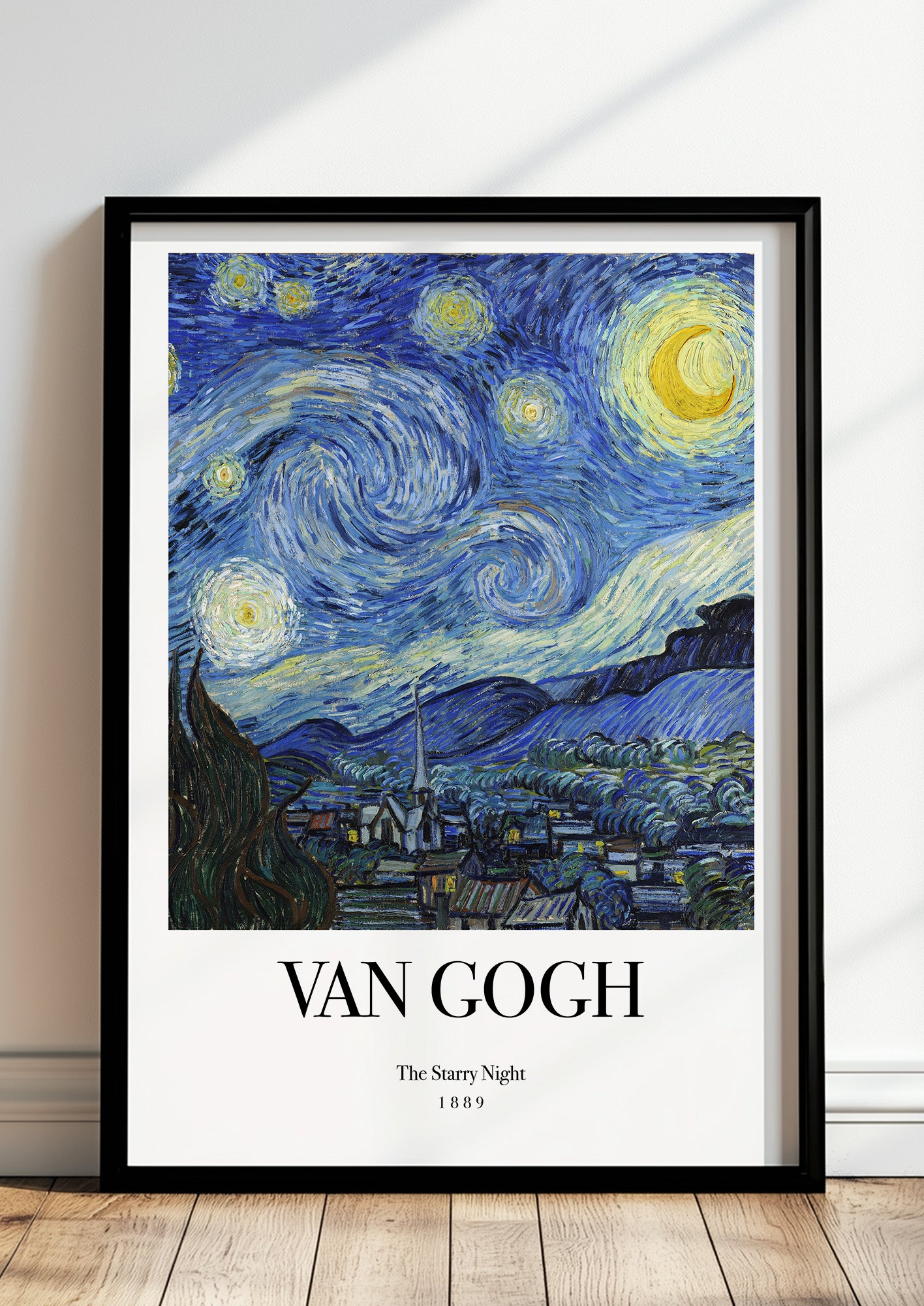 The Starry Night von Vincent van Gogh als Poster, in schwarzem Rahmen, stehend auf dem Boden, angelehnt an einer Wand