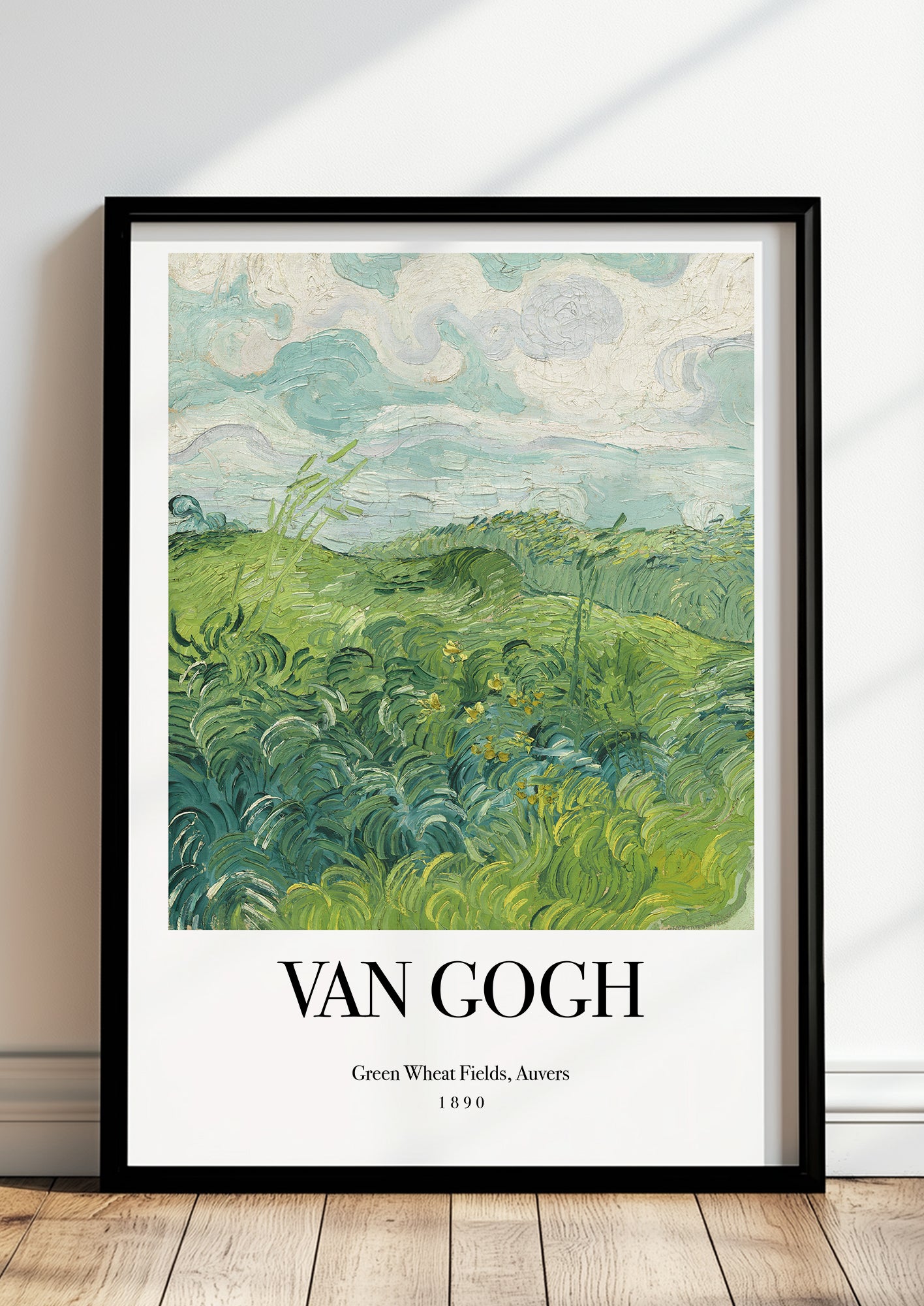 Green Wheat Fields, Auvers No. 2 von Vincent van Gogh als Poster, in schwarzem Rahmen, stehend auf dem Boden, angelehnt an einer Wand