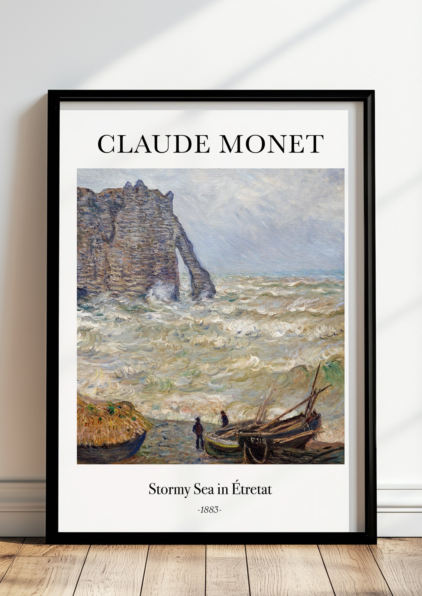 Stormy Sea in Étretat von Claude Monet als Poster, in schwarzem Rahmen, stehend auf dem Boden, angelehnt an einer Wand