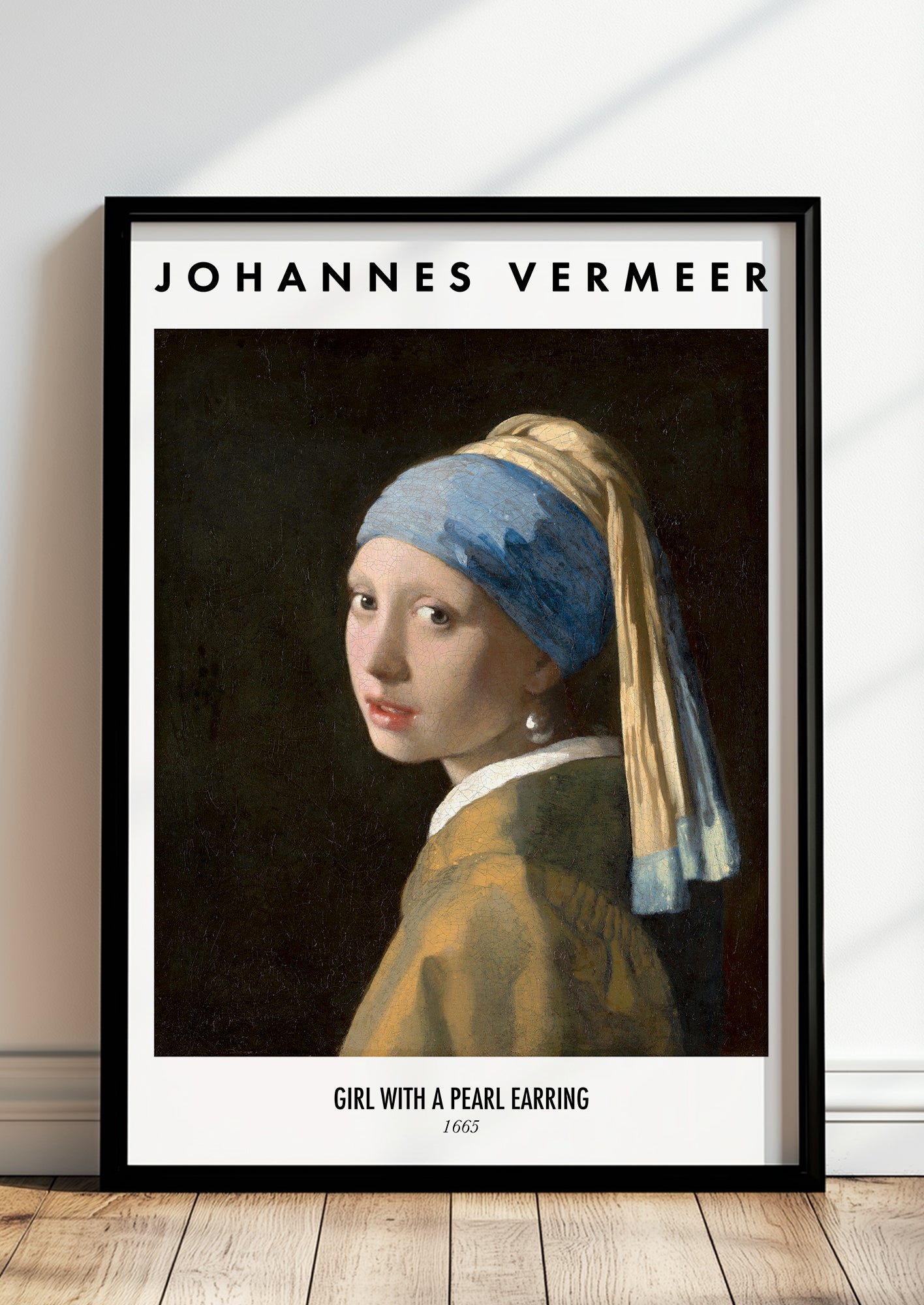 Girl with a Pearl Earring von Johannes Vermeer Kunstdruck im schwarzen Rahmen, an Wand gelehnt