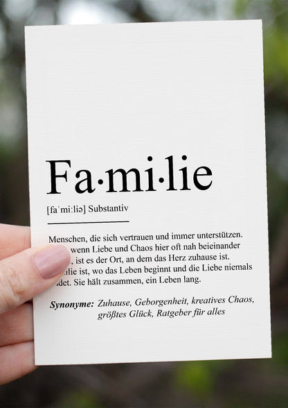 Grußkarte Familie in der Hand vor grünem Hintergrund