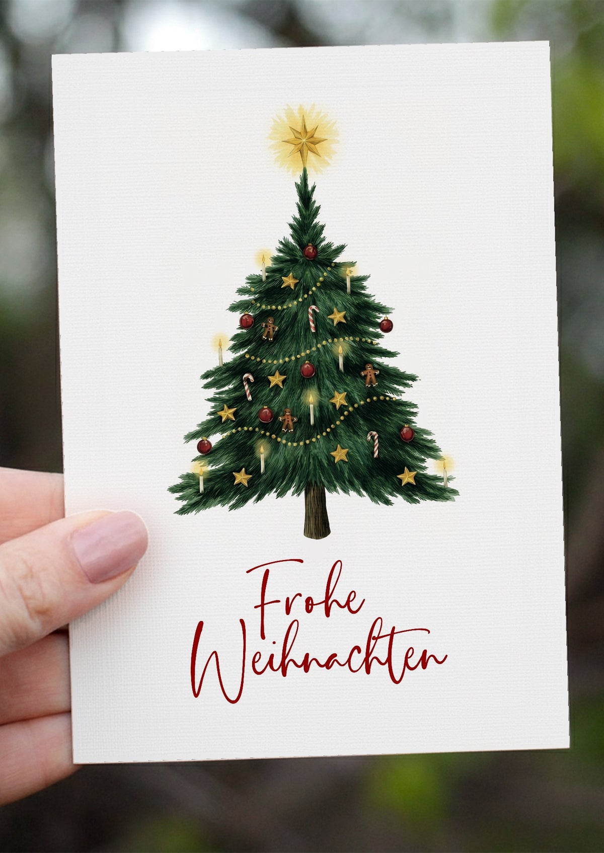 Weihnachtskarte Frohe Weihnachten in der Hand vor grünem Hintergrund