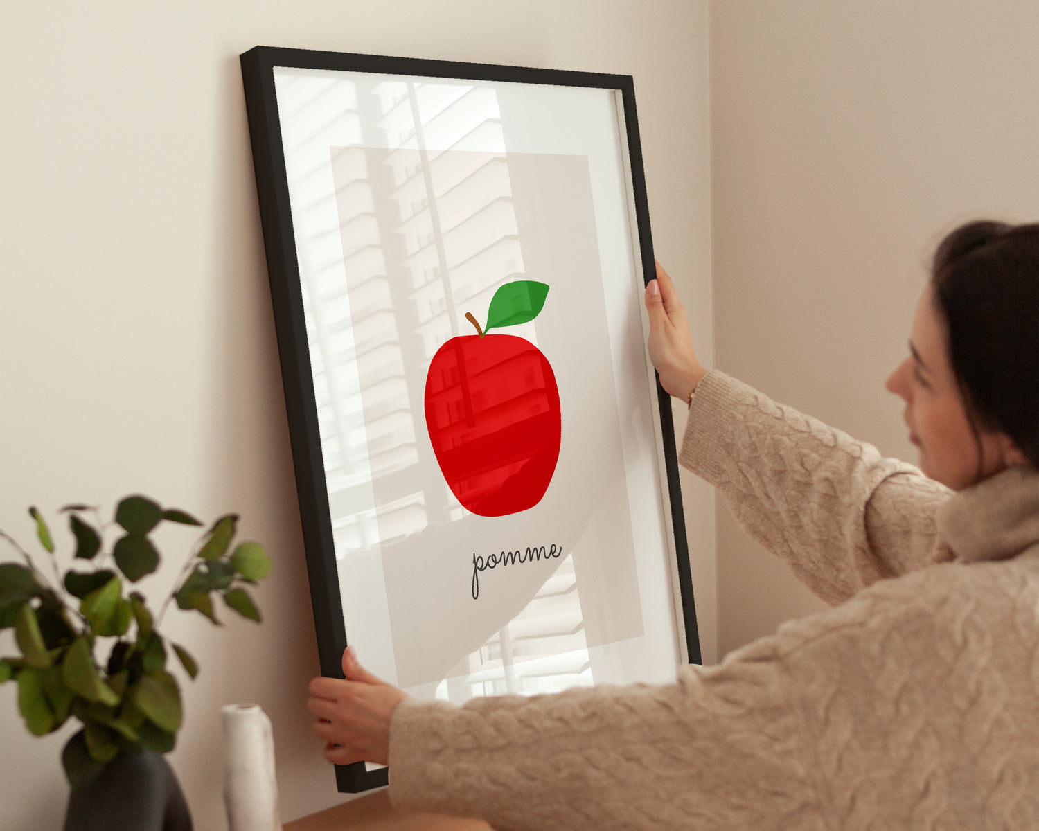 Person hängt Poster „Apple Illustration - Pomme“ auf.