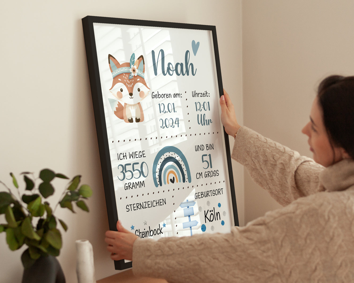 Frau hängt geburtsposter Junge Personalisiert auf mit schwarzem Rahmen