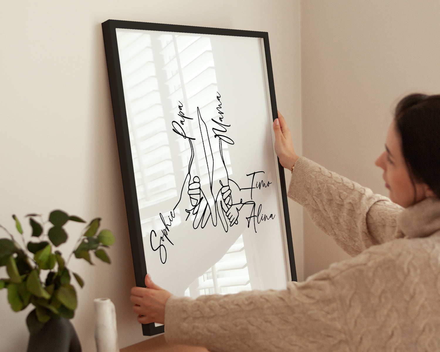 Frau dekoriert ihr Zuhause – One Line Familienposter mit 5 Namen.