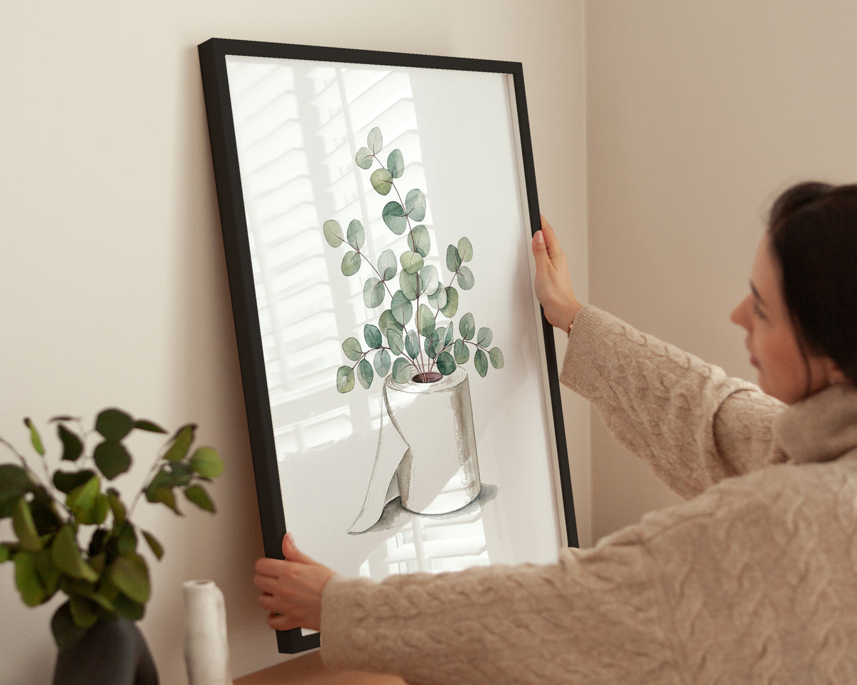 Frau hängt das Eukalyptus Klopapier Poster an eine helle Wand
