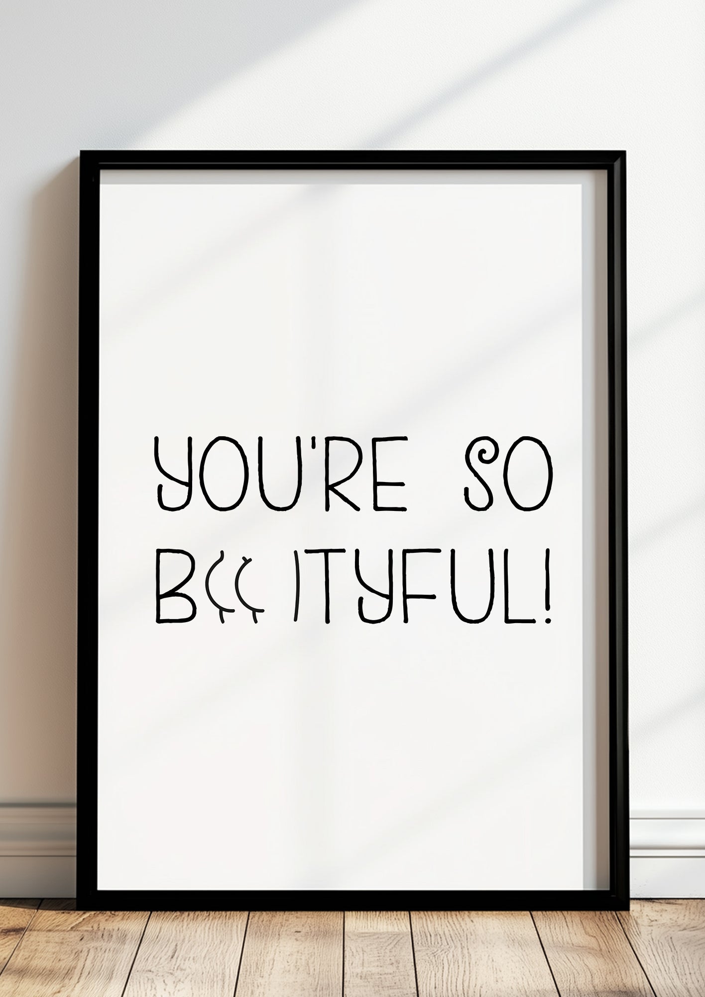 Gerahmtes Poster „You’re so Bootyful!“ in schwarzem Rahmen, inszeniert in moderner Wohnumgebung.