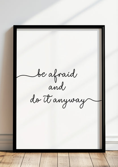 Gerahmtes Poster „be afraid and do it anyway“ in modernem Raum.