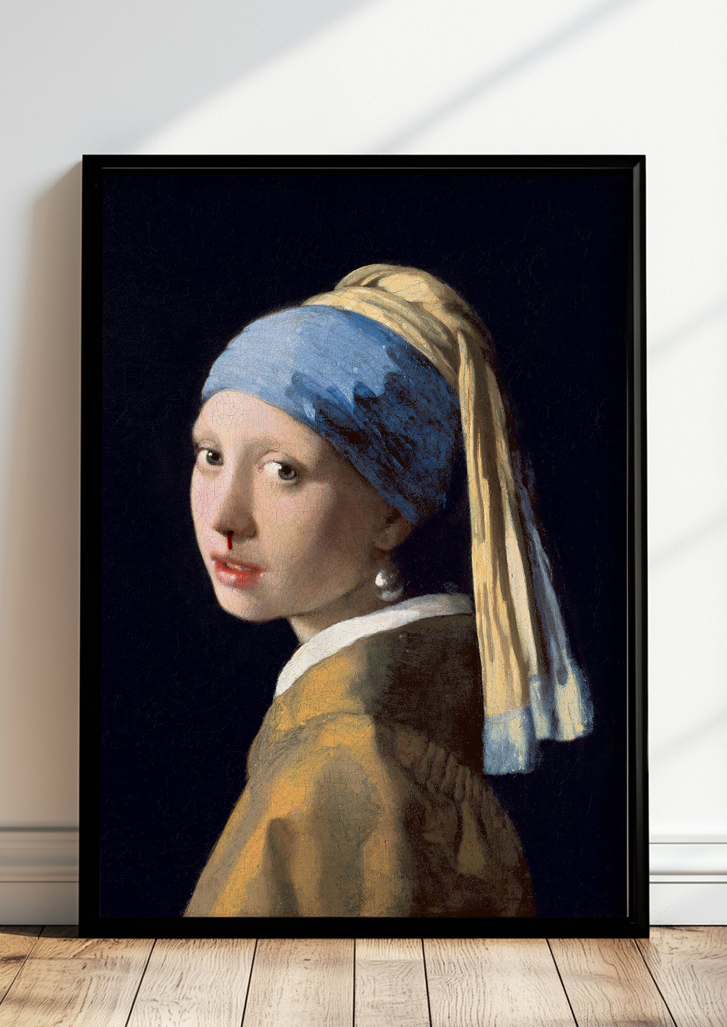 ein modernes kunstposter zeigt das mädchen mit dem perlenohrring und einer feinen roten spur unter der nase an einer weißen wand