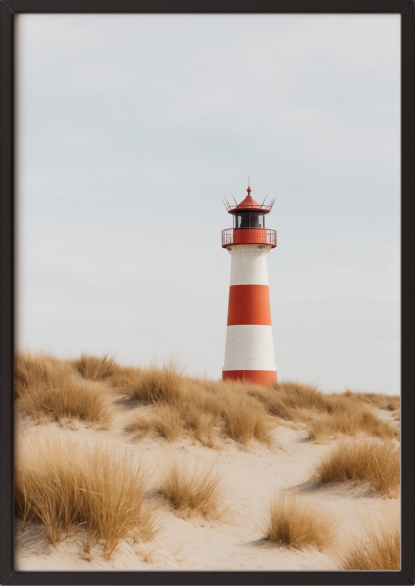 Poster mit Leuchtturm auf Dünenweg im schwarzen Rahmen angelehnt an die Wand