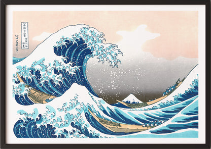 Eine Frau hängt Katsushika Hokusai – The Great Wave off Kanagawa in schwarzem Rahmen an die Wand